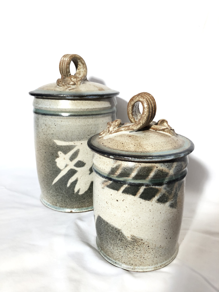 Two dry good jars with lids glazed in a neutral turquoise color