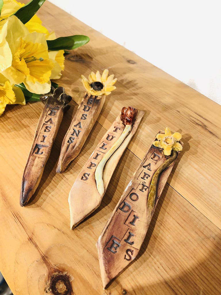 4 plant markers, each with stamped flower names and clay models of flowers
