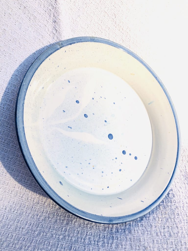 A large blue platter glazed in white with blue speckles and rim