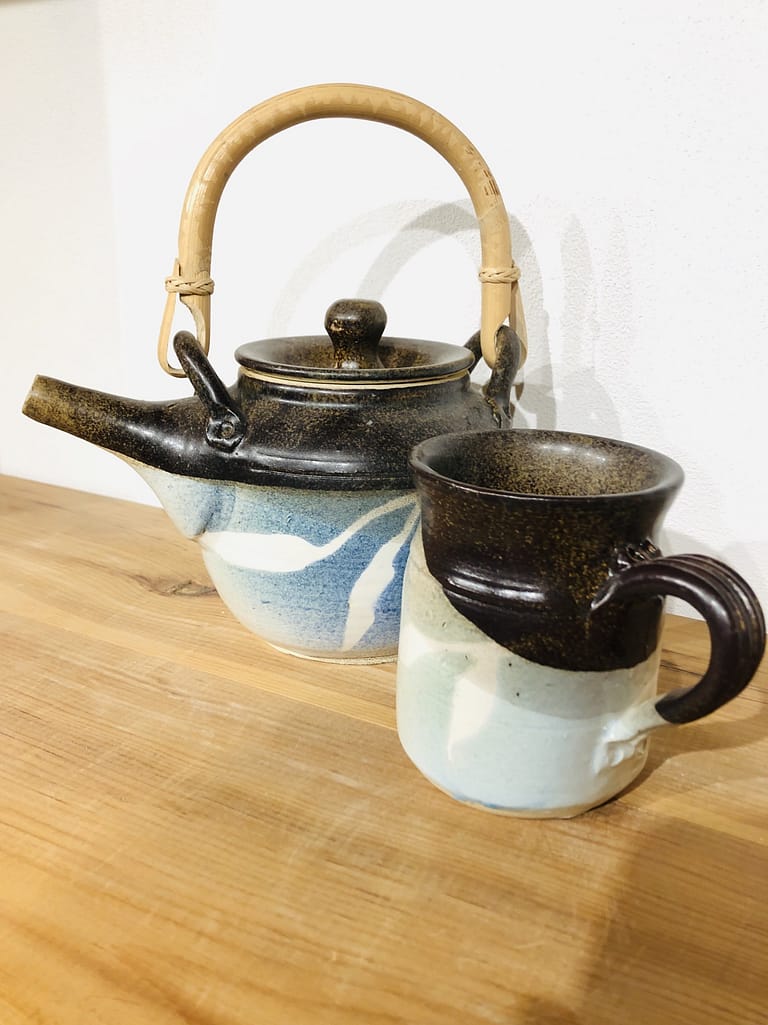 A teapot and matching mug glazed in blue and temmoku brown