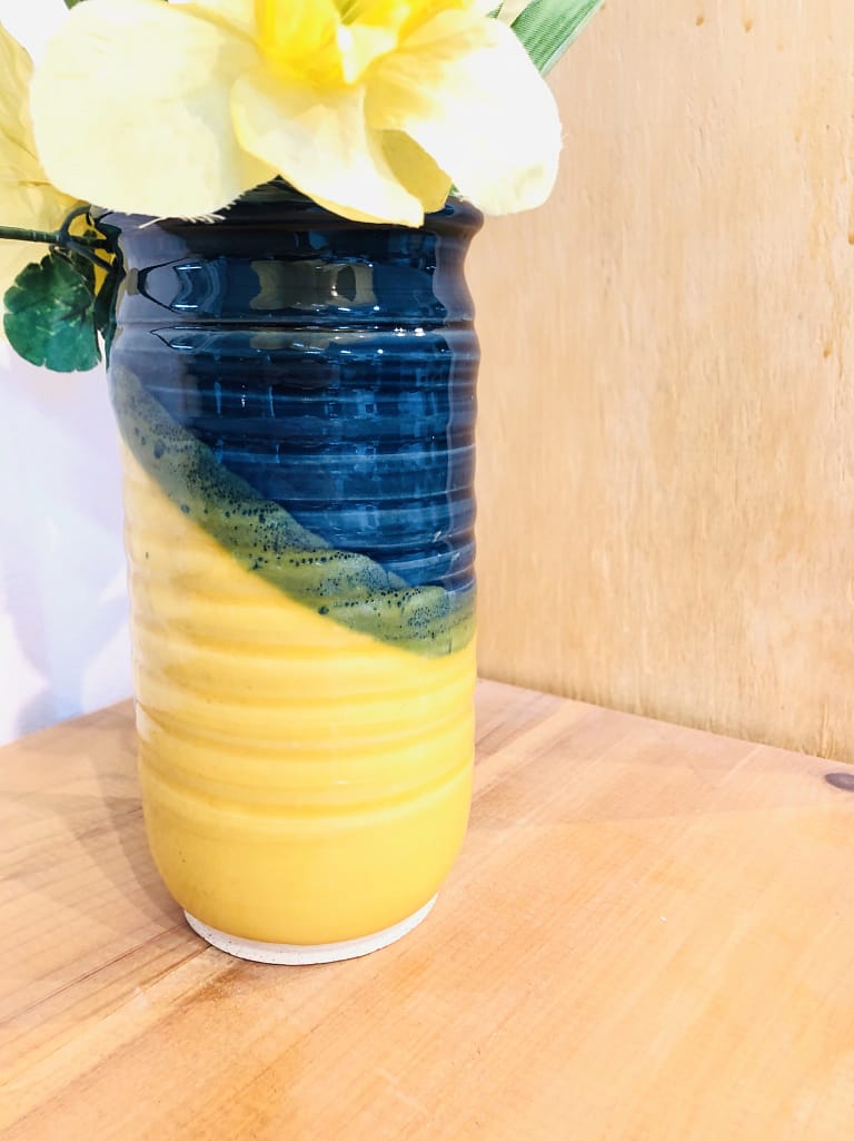 A tall vase in blue and bright yellow glazes