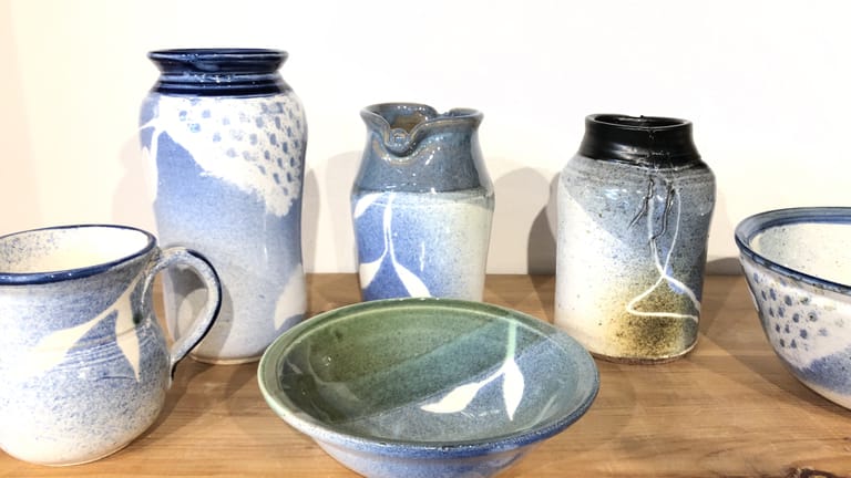 An assortment of vases, cups, and mugs, in blue, green, and turquoise glazes