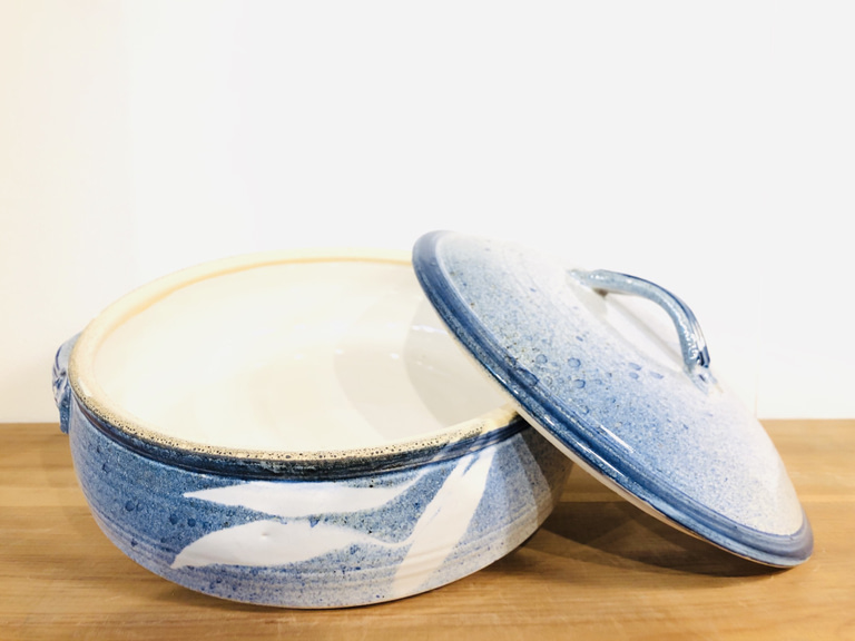 A casserole dish and lid glazed with white and blues