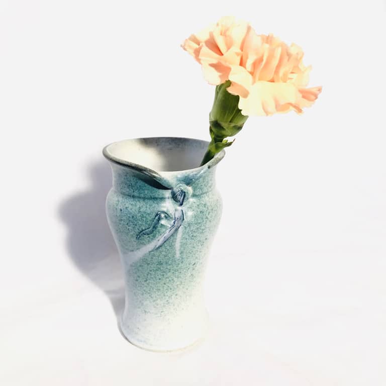 A small vase with a curvy side profile and glazed with turquoise